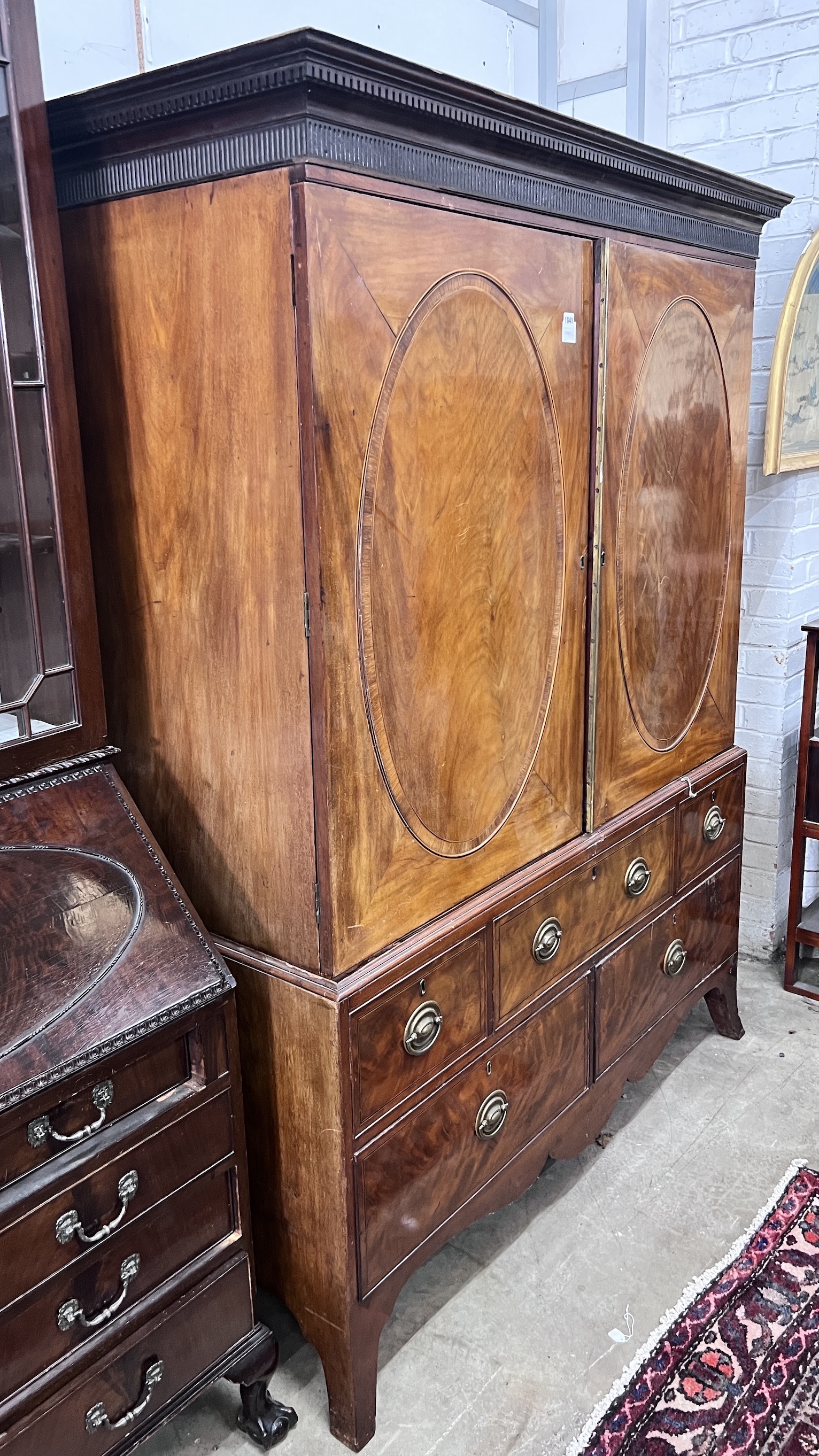 A George III banded mahogany linen press converted to a hanging wardrobe, width 147cm, depth 64cm, height 191cm